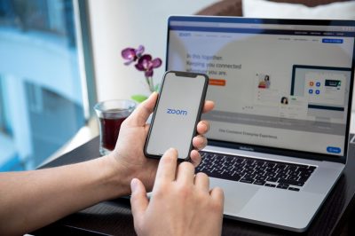 Man hand Macbook and iPhone calling Zoom Video Communications ap Alanya, Turkey - April 10, 2020: Man hand on Macbook Pro 16 and iPhone 11 with calling Zoom Video Communications application