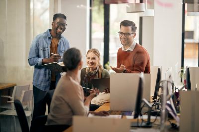 Group of young business colleagues communicating and having fun on a meeting in the office.